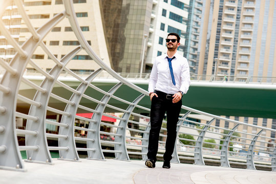 Young Handsome Man In Full Suit Walking Down Street Smiling.