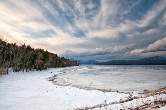 Ashokan Reservoir winter scene with dramatic sky, mountains, snow and ice. Ashokan reservoir provides water to New York City. It is located in the Mid-Hudson Valley of NY.
