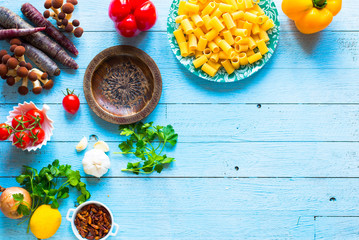 Top view of italian ingredients for spaghetti, over a wood background.