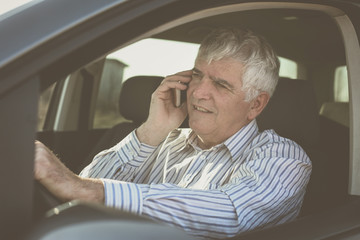 Businessman using a phone, sitting in car.