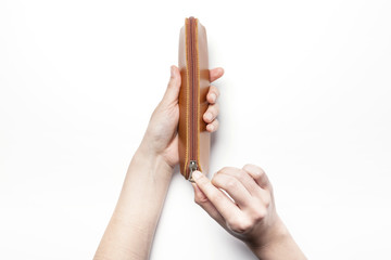 woman(female)'s hand hold a brown leather pencil case isolated white.