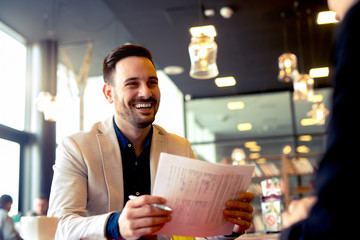Cheerful young man looks happy after doing all paper work.