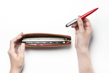 woman(female)'s hand hold a leather pencil case with a red pen isolated white.