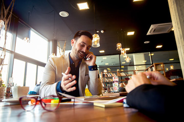 Man in full suit makes phonecalls working on new project.