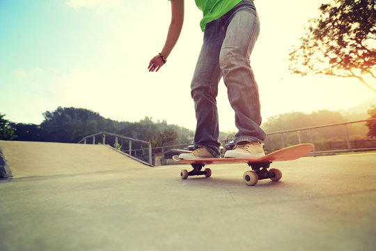 people legs practice skateboarding at skatepark