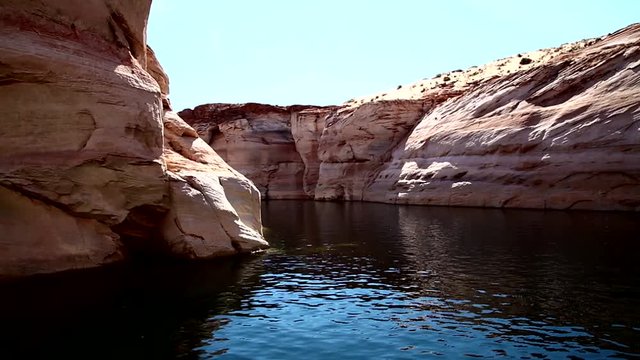 The boat goes through the narrow canyon. Lake Powell is a reservoir on the Colorado River that spans 200 miles. Houseboats and powerboats cruise through the lake's natural canyons. it was the location