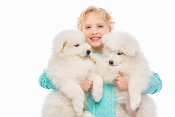 Little girl with a samoyed puppies