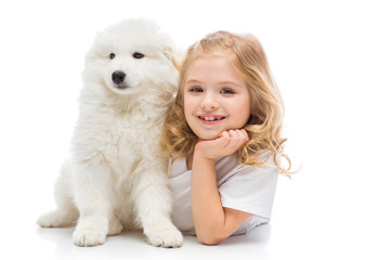 Little girl with a samoyed puppy