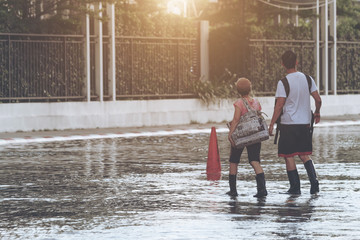 People wade through flood, concept of natural disaster.