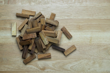 Top view of the tower stack from wooden blocks toy and man's hand take one block