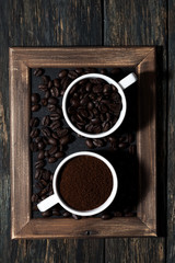 ground coffee and coffee beans in cups, top view vertical