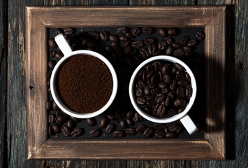 ground coffee and coffee beans in cups, top view