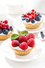 mini tarts with cream and berries, vertical