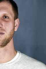 Obraz premium Portrait of the young smiling man on gray background, Cropped image