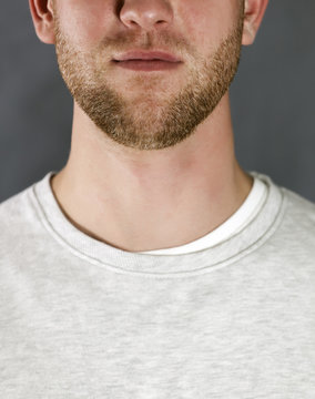 
Portrait of the young smiling man on gray background, Cropped image
