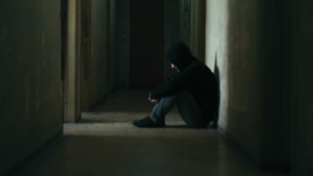 Following a hooded young man inside a dark derelict ghetto building,slow motion dramatic