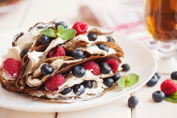 Pancakes with blueberries and raspberries, mascarpone cream and tea