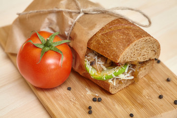 Big sandwich on wooden cutting board with ingridients