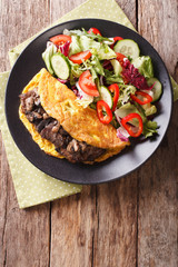 Austrian Imperial Steak with mushrooms, scrambled eggs and fresh salad closeup. vertical top view