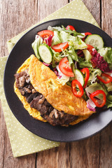 Austrian cutlet with mushrooms, scrambled eggs and vegetable salad close-up. vertical top view
