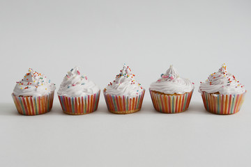 Cupcakes with white cream and sprinkles