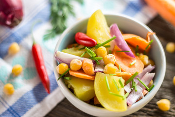Vegetable Salad with Chickpea on Tablecloth and Wooden Background