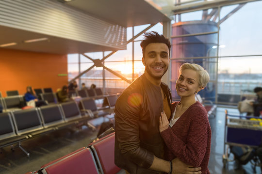 Young Couple In Airport Lounge Waiting Departure Happy Smile Hispanic Man And Woman Flight