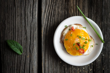 Fried Egg with Chives and Basil Leaf on White Plate