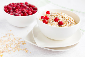 Rolled oats, porridge and cranberries for a healthy breakfast in a rustic style