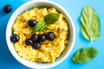 Puree of Millet Grains with Blueberries on Blue Background.