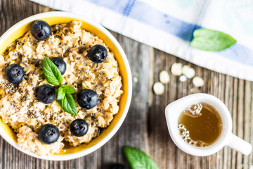 Porridge - Oat Flakes with Blueberries and Mint Leaves on Tablecloth