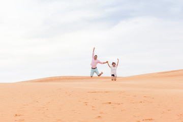 Young Man Woman Jump Up In Desert Beautiful Couple Asian Girl And Guy Sand Dune Landscape Background