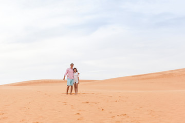 Fototapeta na wymiar Young Man Woman In Desert Beautiful Couple Asian Girl And Guy Embrace Sand Dune Landscape Background