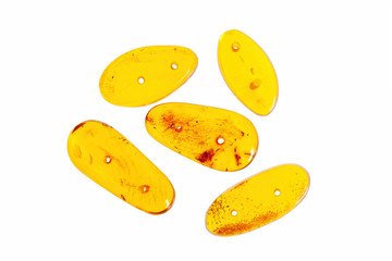 Five yellow amber stones on a white background.