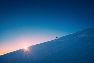 A climber climbs up a snowy slope