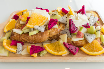 Close up of French toast with kiwi, apple, Dragon Fruit, orange and honey