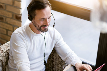 Handsome bearded man using modern devices in the cafe