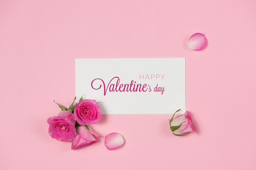 Valentine's Day greeting card with rose flowers over wooden background. Top view with copy space