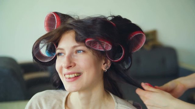 Closeup of happy women friends make fun curler hairstyle each other and have fun
