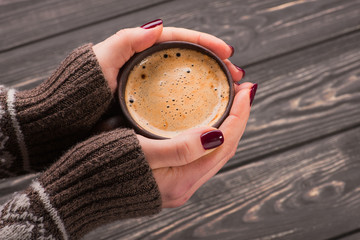 woman holding a hot cup of coffee