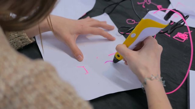 Close up shot. Woman using 3D printing pen. Exhibition of modern technologies. Future and technology concept