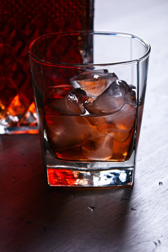 Glass of whiskey with natural ice on a wooden table