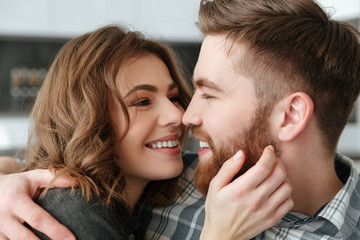 Happy loving couple sitting on sofa indoors