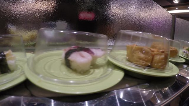 4k, Sushi on conveyor belt in Japan Restaurant, Traditional Japanese food in a restaurant conveyed on a moving belt, Shushi Go Round is a form fast-food common in Asia, also known as sushi train -Dan