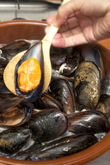Woman hand cooking steamed mussels