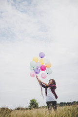 Beautiful young hipster woman holding with colorful of balloons outdoor, Freedom enjoy with nature. Women lifestyle concept.