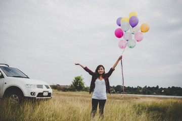 Beautiful young hipster woman holding with colorful of balloons outdoor, Freedom enjoy with nature. Women lifestyle concept.