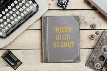 House hold budget on old book cover at office desk with vintage items © MichaelJBerlin