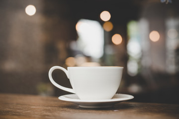 Vintage style effect picture of coffee cup in cafe.