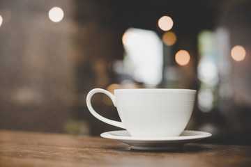 Vintage style effect picture of coffee cup in cafe.